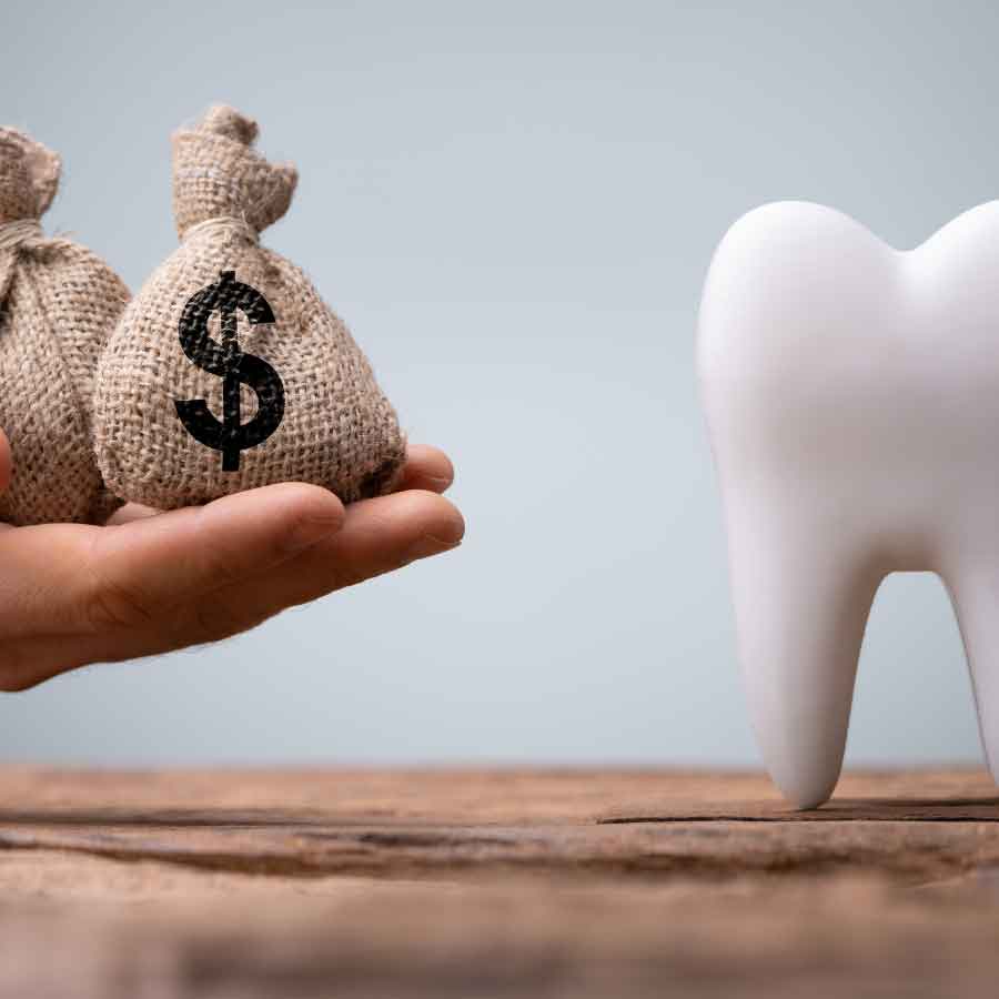 An image showing a 3D white tooth on the right and a hand holding two burlap money bags with dollar signs on the left