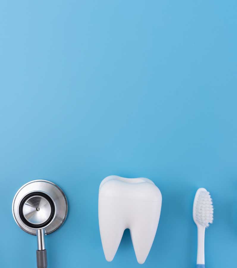 Examination tools arranged on a blue background, including a dental mirror, a stethoscope, two model teeth, a toothbrush, and dental floss